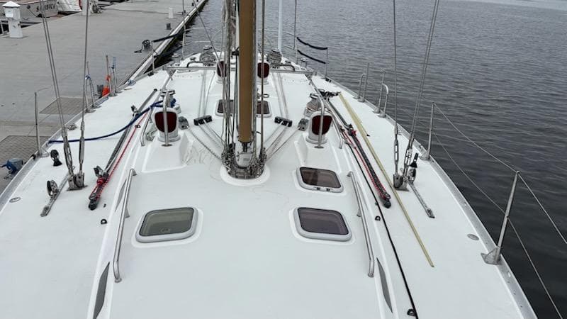 2003 J Boats J/46 sailboat deck with rigging and hatches, docked by the water.