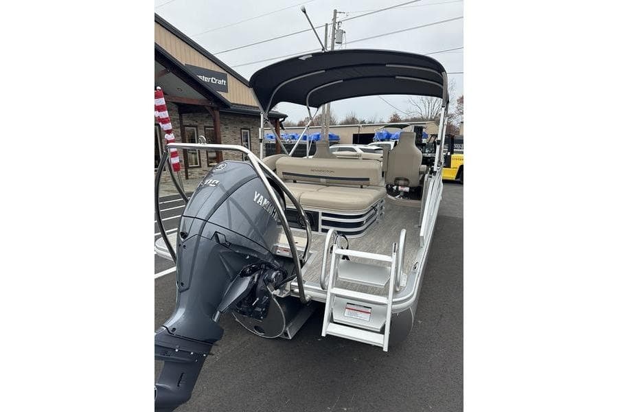 2026 Bennington M Swingback 24 MSB pontoon boat with Yamaha outboard motor, docked outdoors.