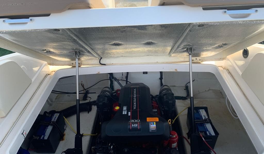 2014 Chaparral 257 SSX engine compartment with open hatch, revealing V8 engine and batteries.