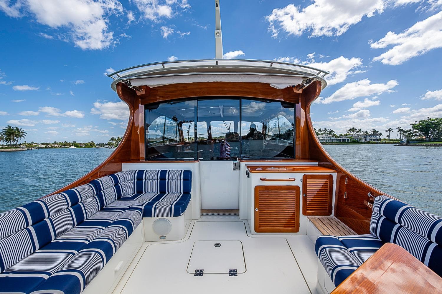 2021 Hinckley Talaria 43 yacht interior with striped seating, wooden accents, and scenic water view.