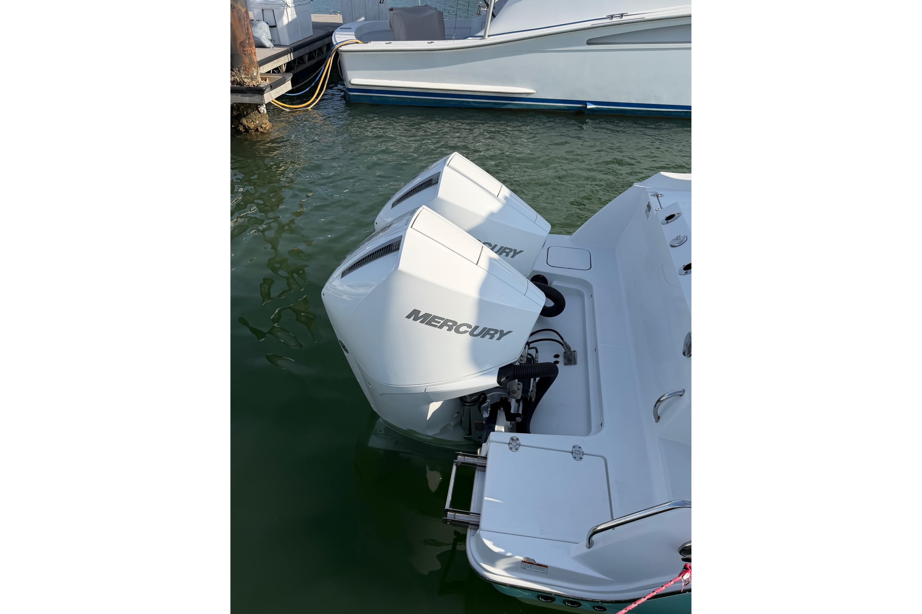 2021 Blackfin 252 CC with dual Mercury outboard engines docked in marina.