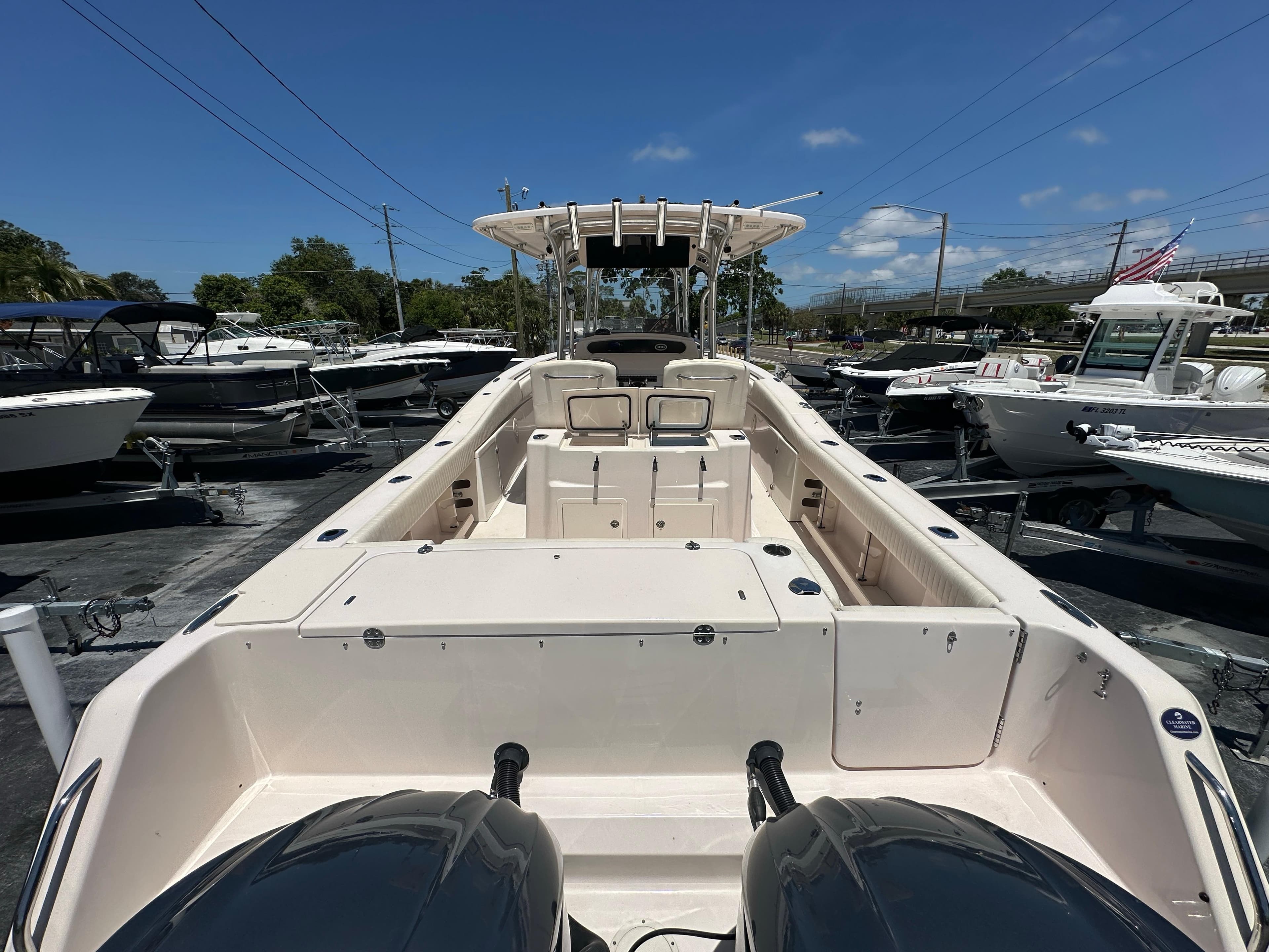 2013 Grady-White Canyon 306 boat with dual engines, docked under a clear blue sky.
