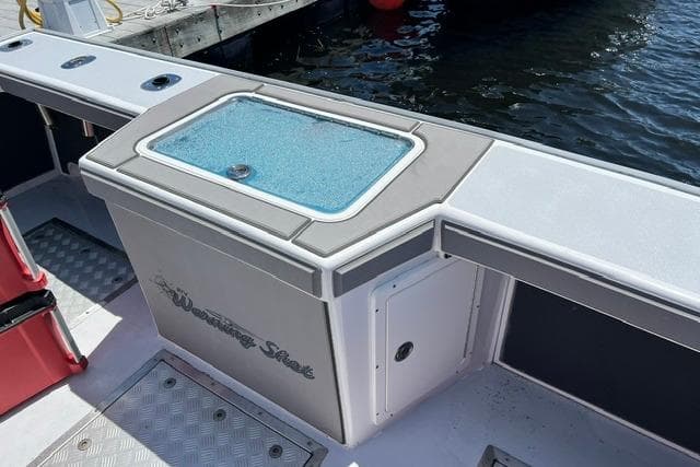 Northern Bay 38 boat deck with livewell, docked by the water.
