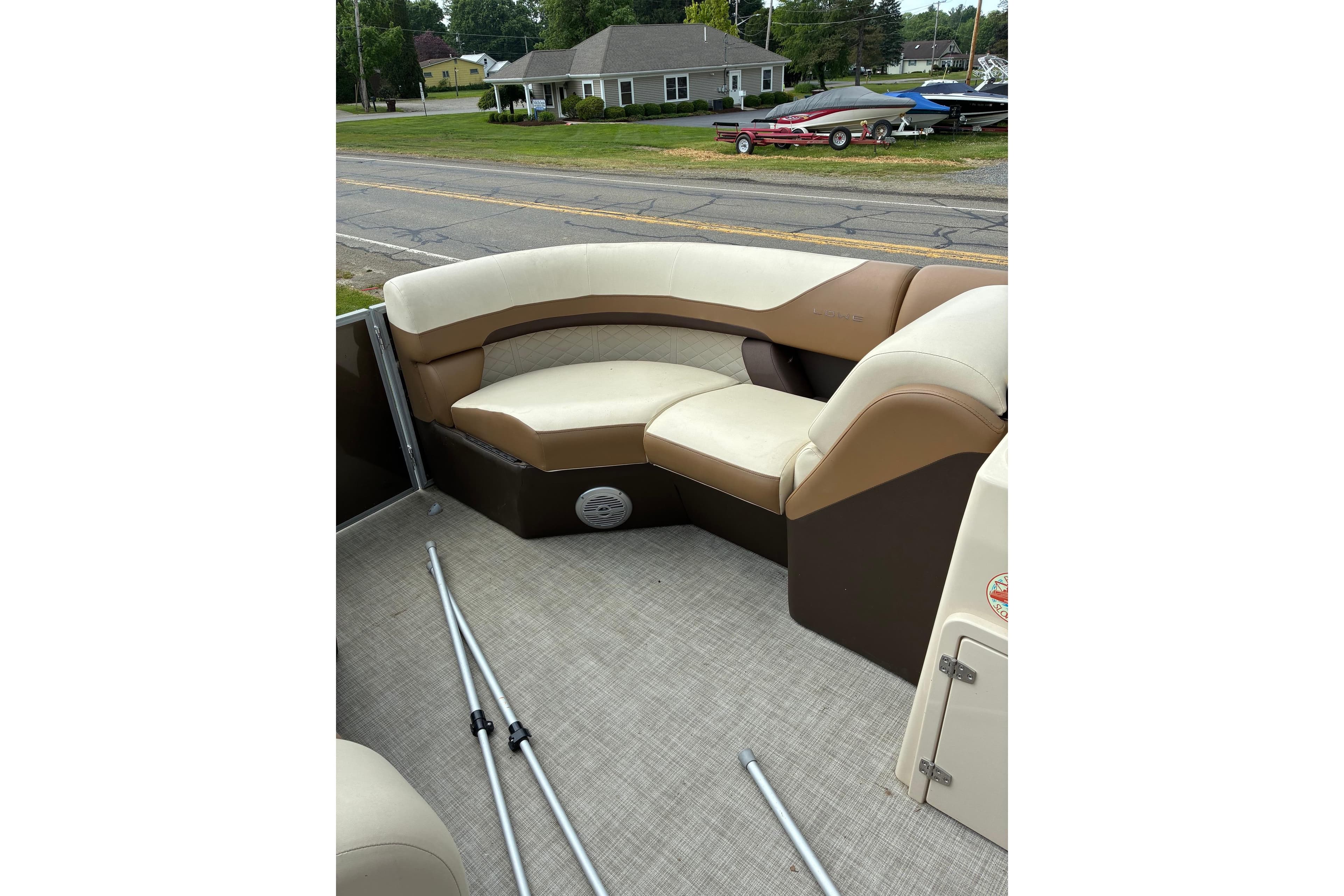 Interior of a 2022 Lowe boat with beige seating and outdoor view.
