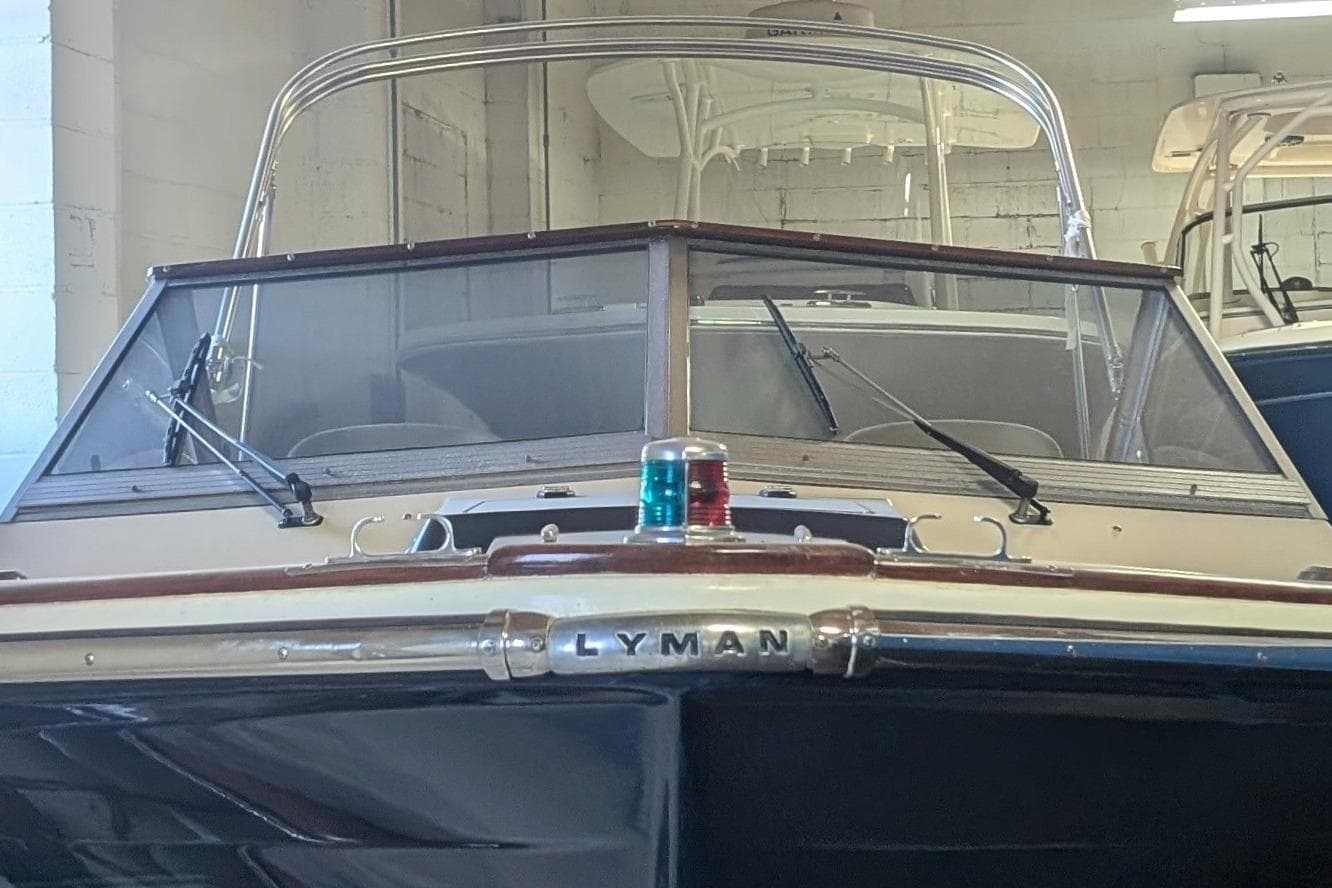 1973 Lyman Islander boat in a garage, showcasing classic design and windshield details.