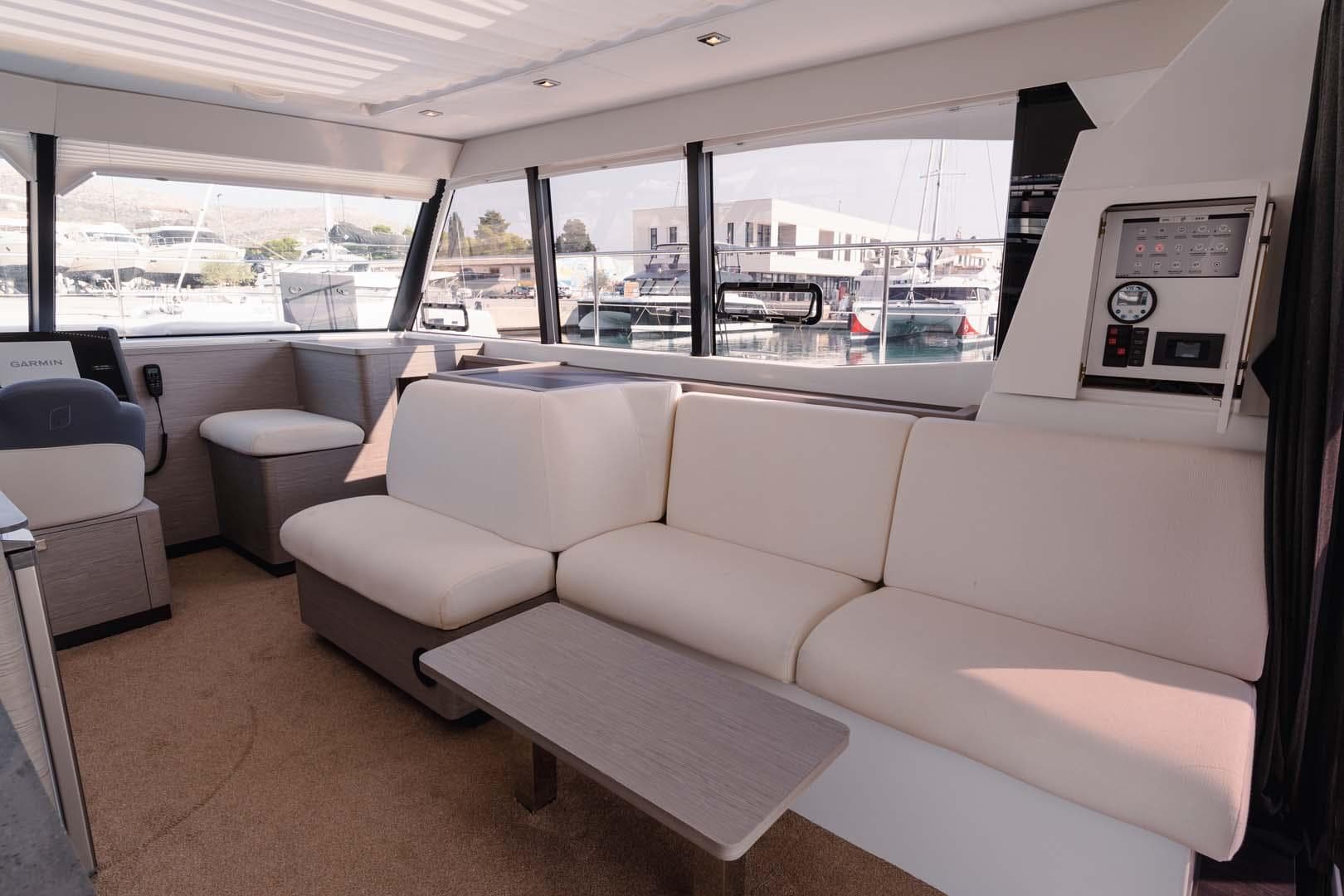 Luxurious interior of 2022 Fountaine Pajot MY4.S yacht with modern seating and panoramic windows.