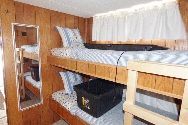1988 Sumerset 14x65 houseboat interior with wooden bunk beds and striped bedding.