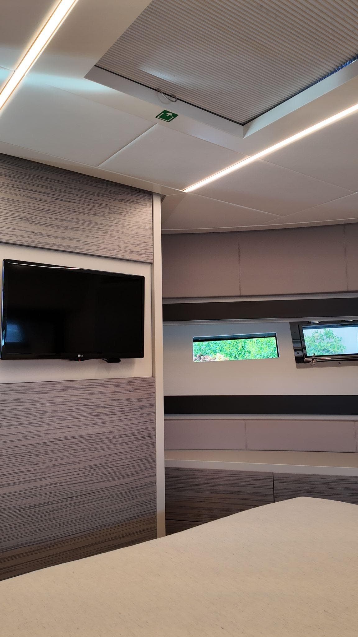 Interior of 2022 Pershing 6X yacht with modern design, TV, and windows.