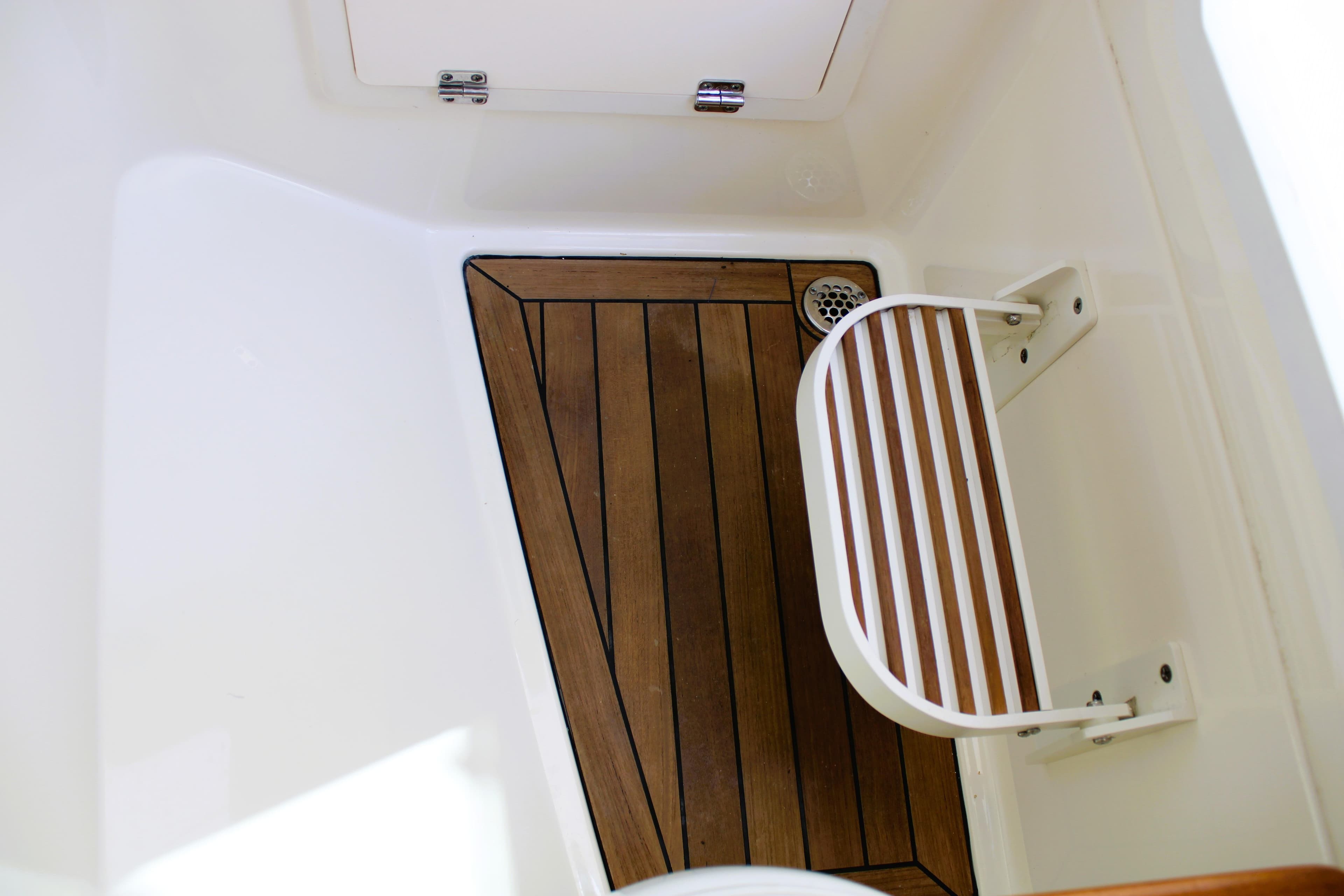 2021 Boston Whaler 320 Vantage interior with wooden flooring and foldable seat.