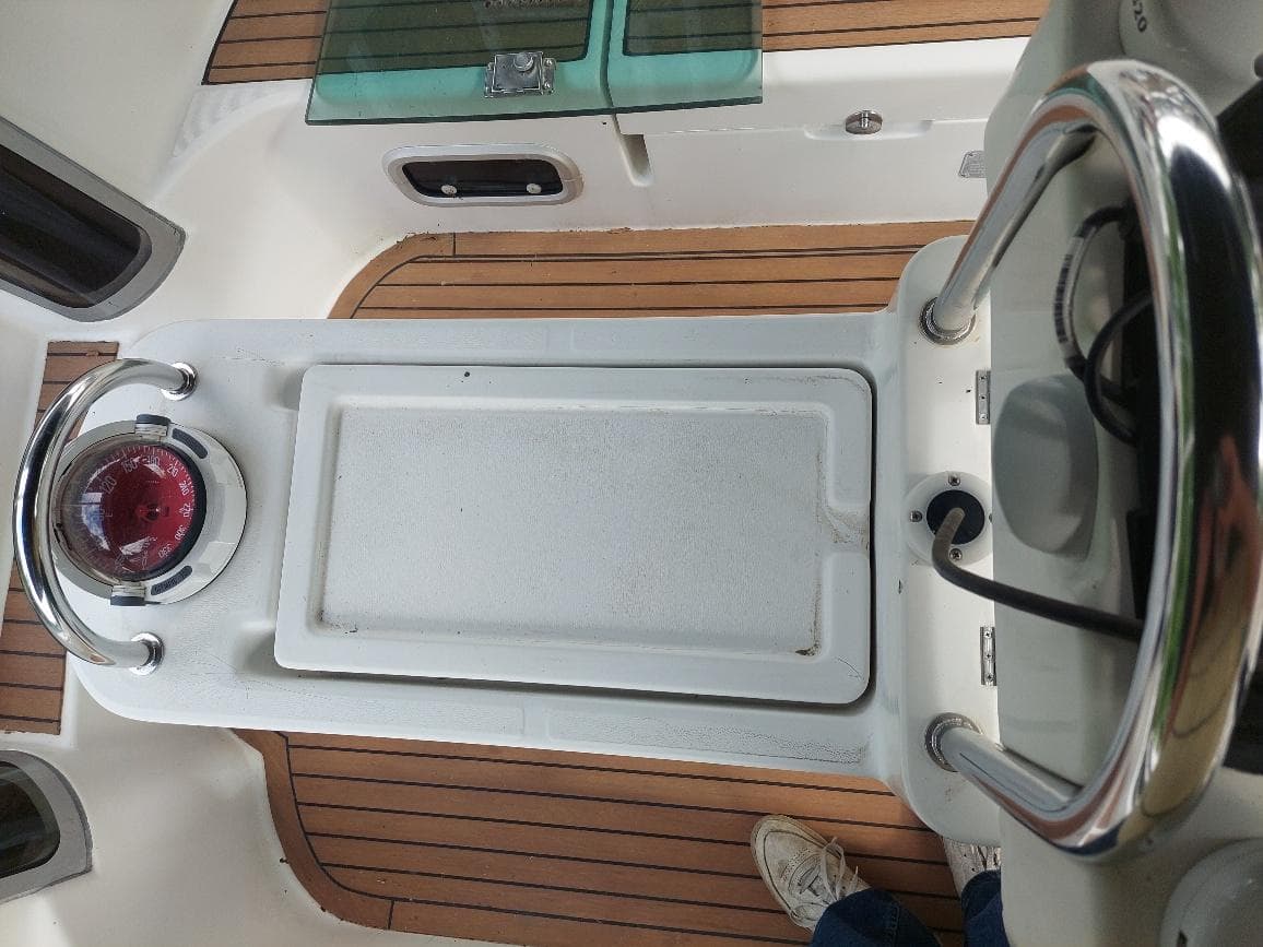 Cockpit view of 1995 Beneteau Oceanis 351 sailboat with teak flooring and steering wheel.