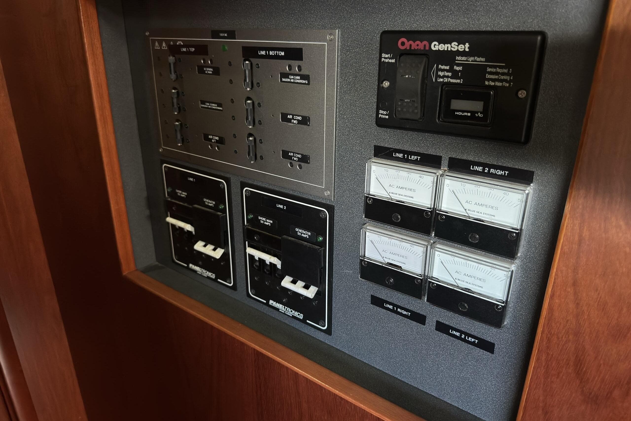 Electrical control panel on a 2003 Beneteau 57 yacht, featuring Onan GenSet and ammeters.