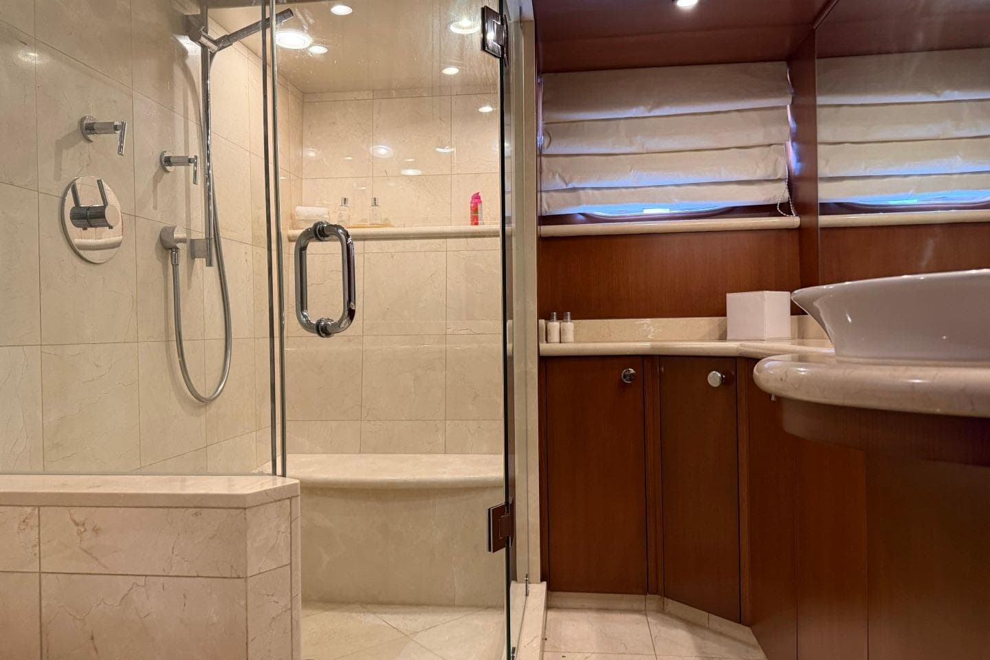 Luxurious bathroom in 1990 Heesen 144 yacht with glass shower and elegant fixtures.