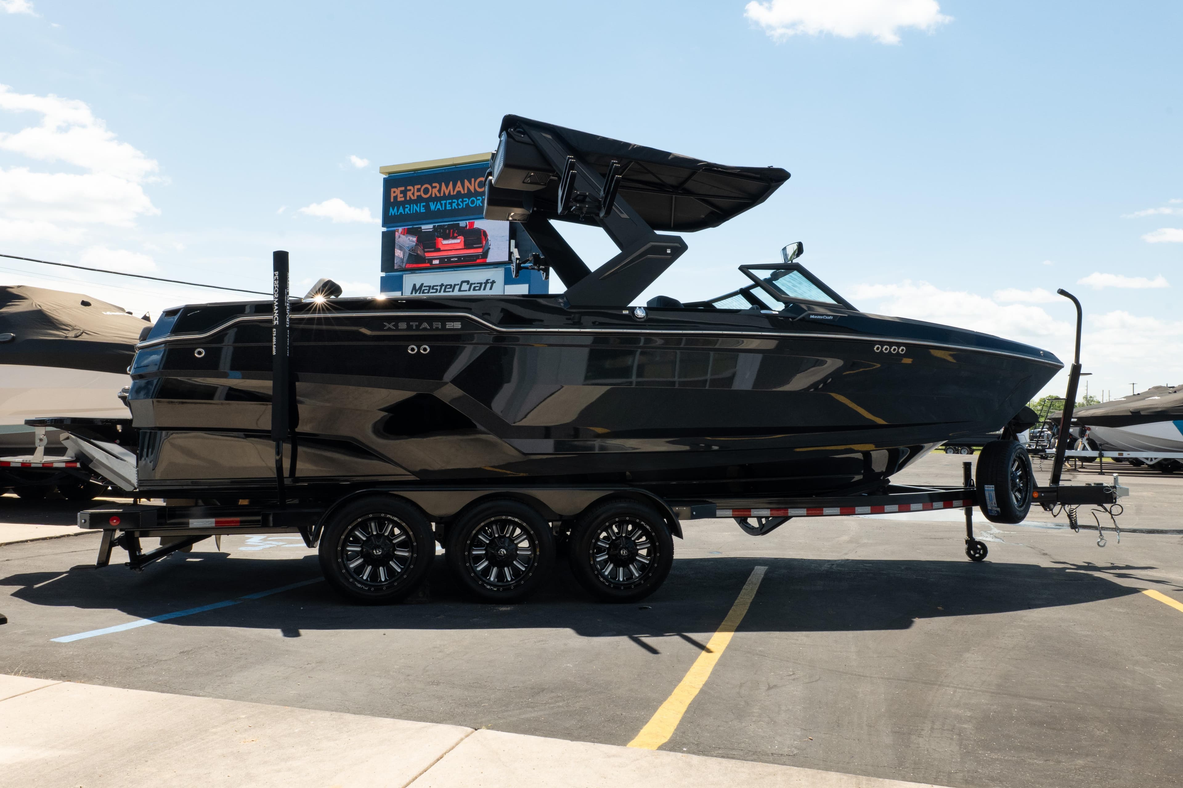 2026 MasterCraft XStar 25 boat on trailer at dealership under clear sky.