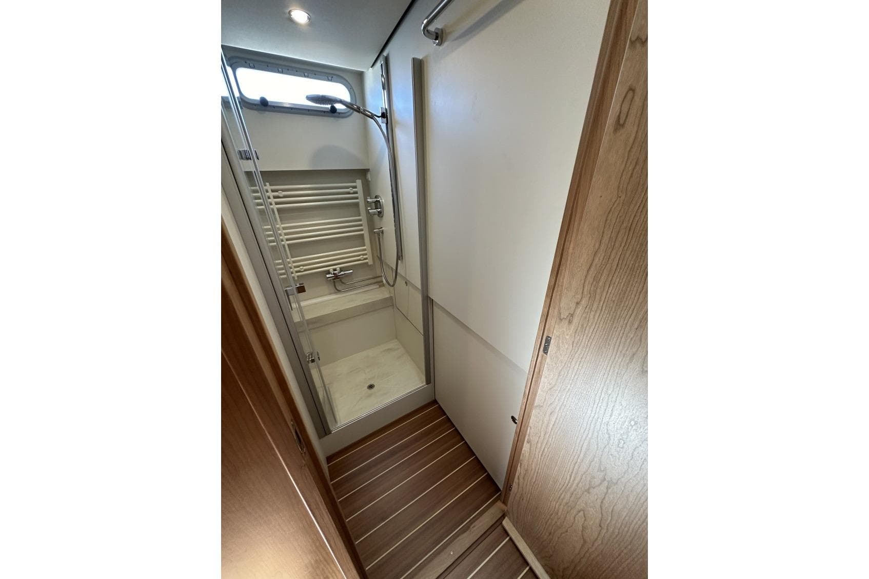 Bathroom interior of 2026 Linssen Grand Sturdy 550 Variotop yacht, featuring shower and wooden accents.