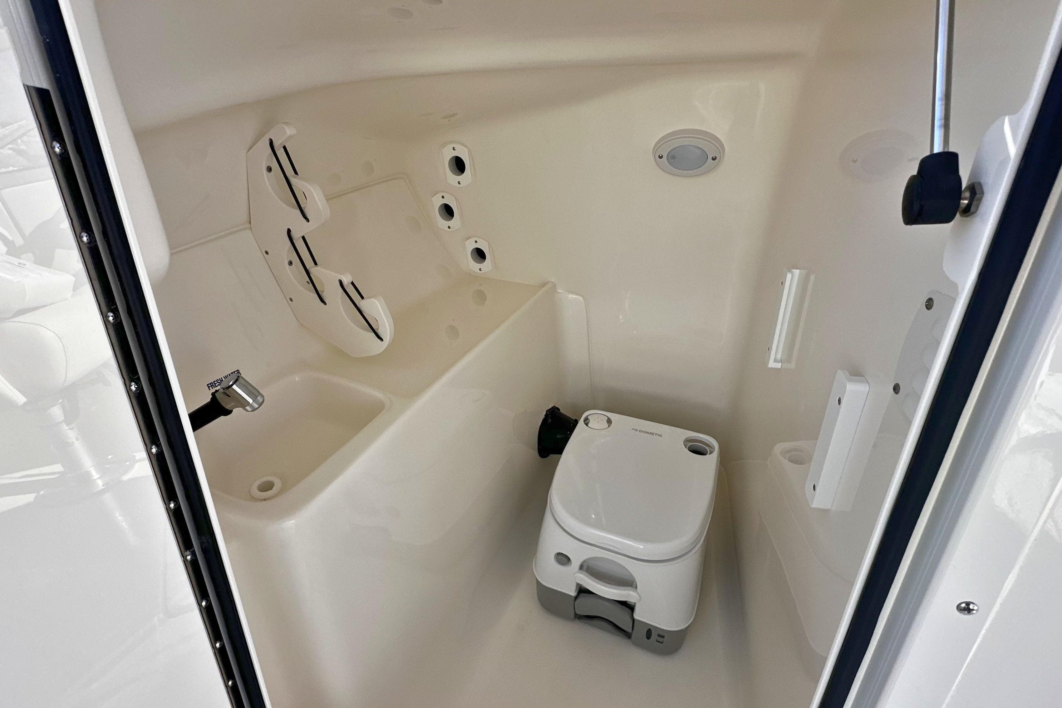Interior of 2026 Key West 239 DFS boat featuring compact marine toilet.