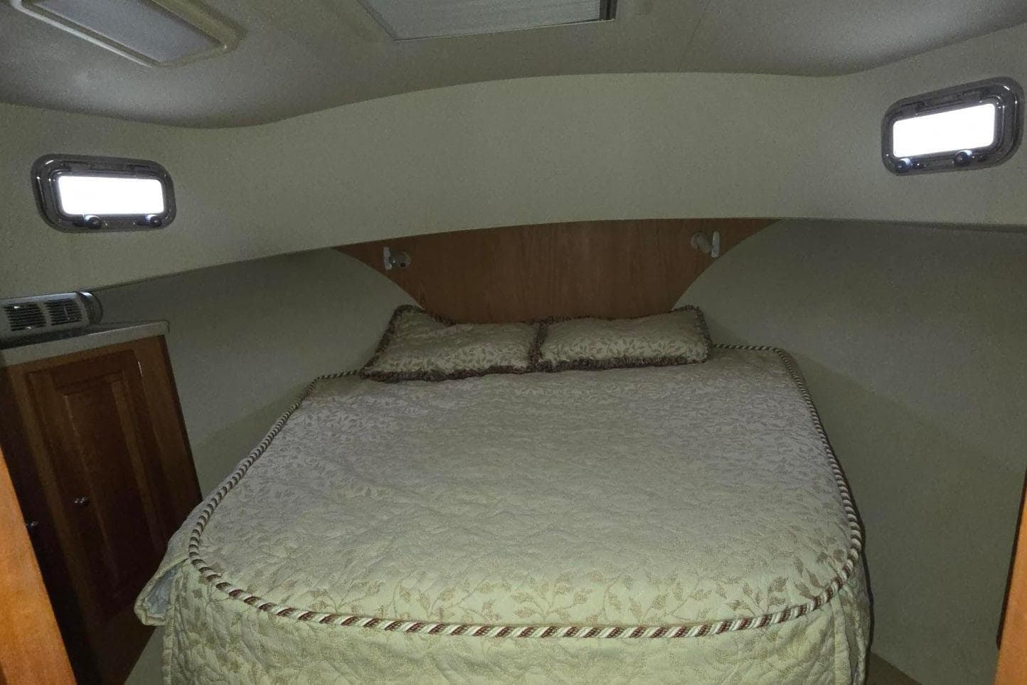 Cozy bedroom in 2006 Mainship 40 Trawler with elegant bedding and natural light.