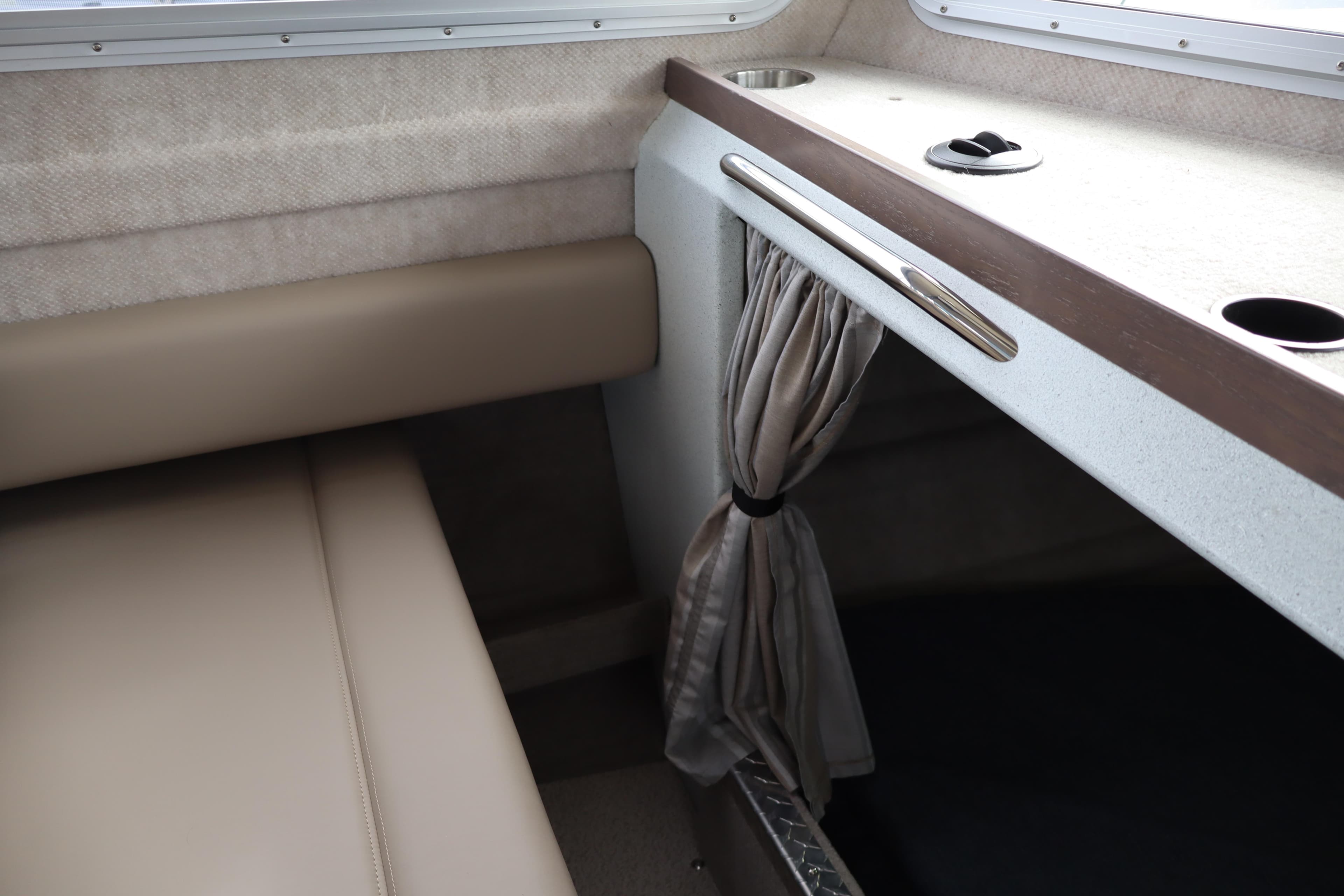 Interior of 2026 KingFisher 3025 XRS boat with beige seating and curtain.