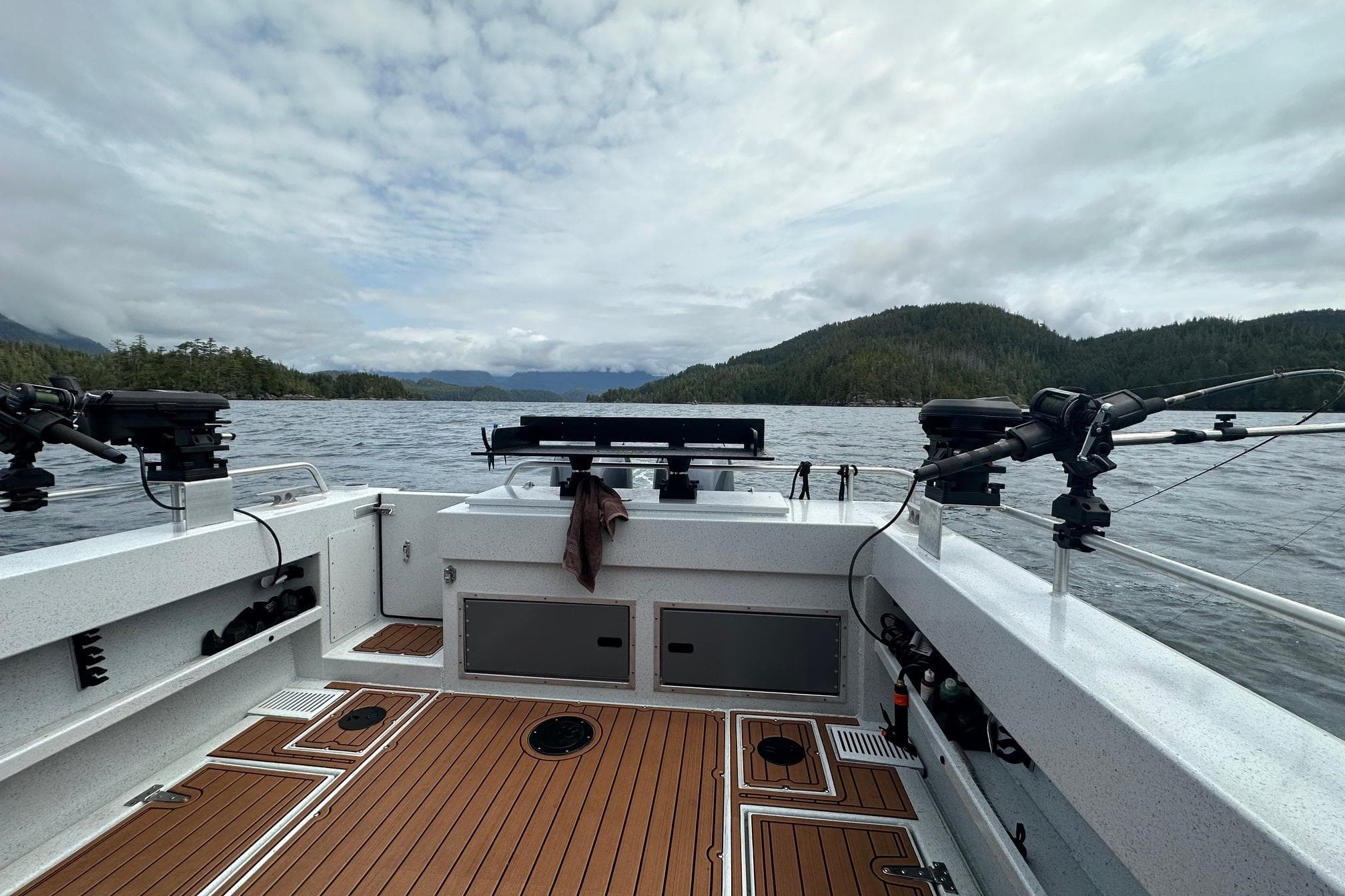 2023 North River 2500 boat on a scenic lake with wooded hills in the background.