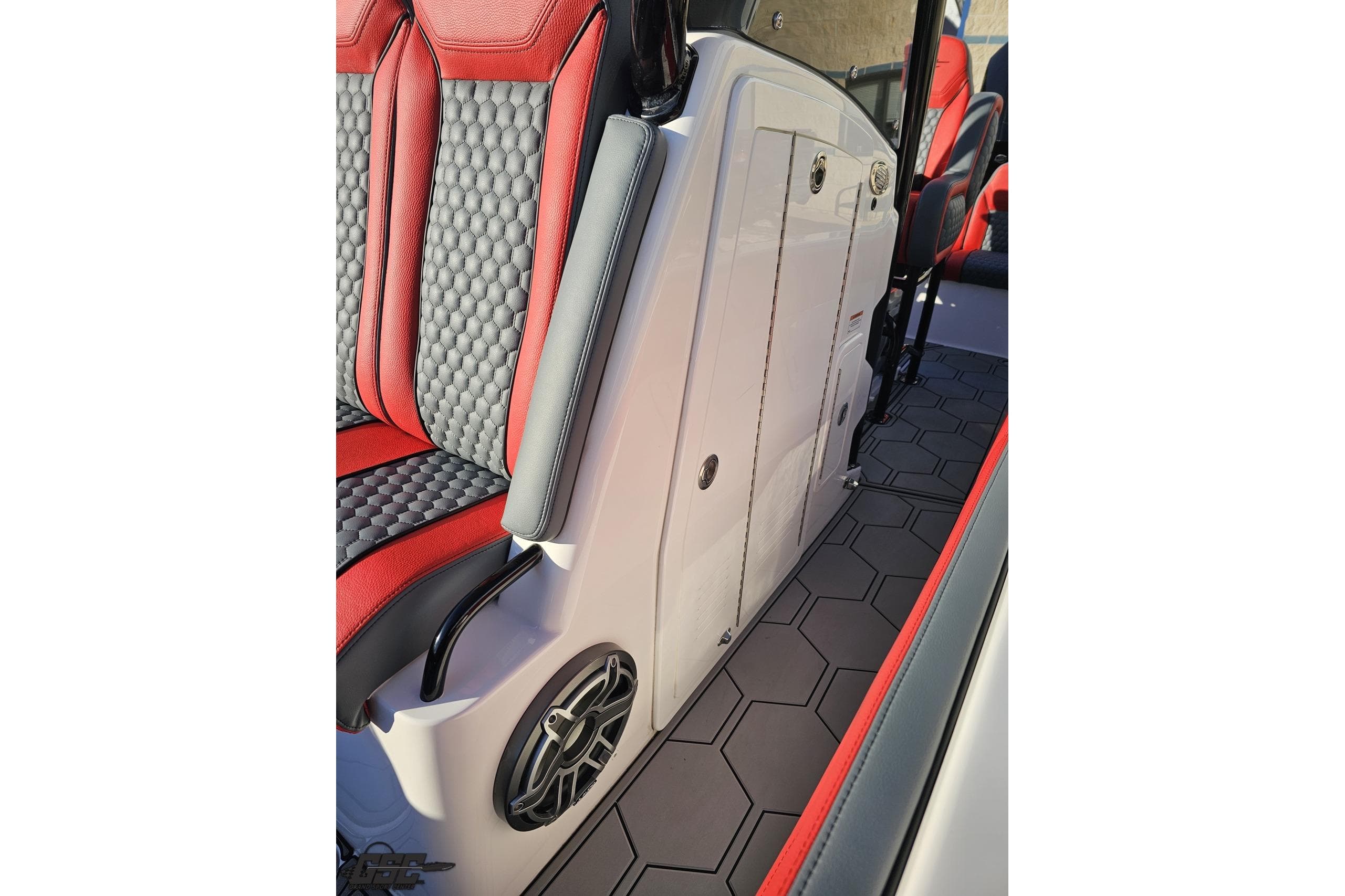 2025 Concept 27' CC boat interior with red and black seating, hexagonal flooring, and speaker.