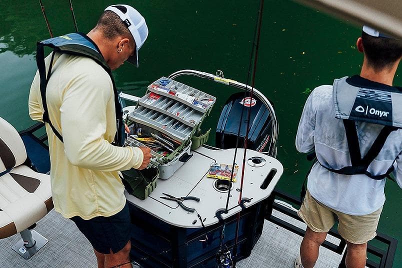 Two people fishing on a 2026 Lowe SF 214 Sport Fish boat with tackle box.