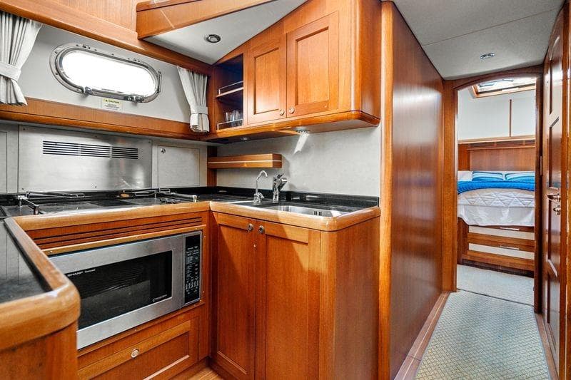 Luxurious 2011 Grand Banks 46 Eastbay SX yacht interior with modern kitchen and cozy bedroom.