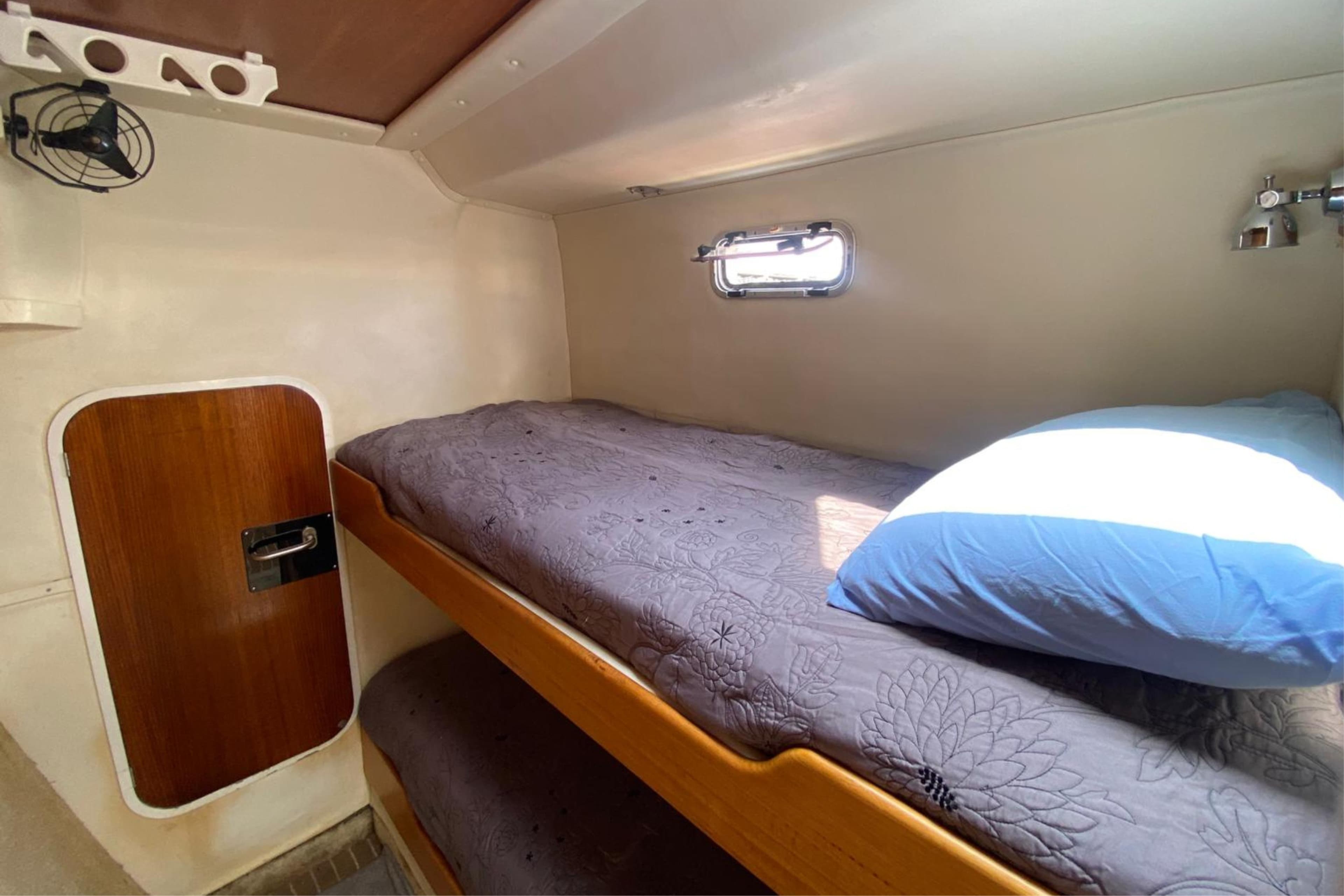 Cozy cabin interior of 2007 Sun Yachts Custom 56 Power Cat with bunk bed and porthole.