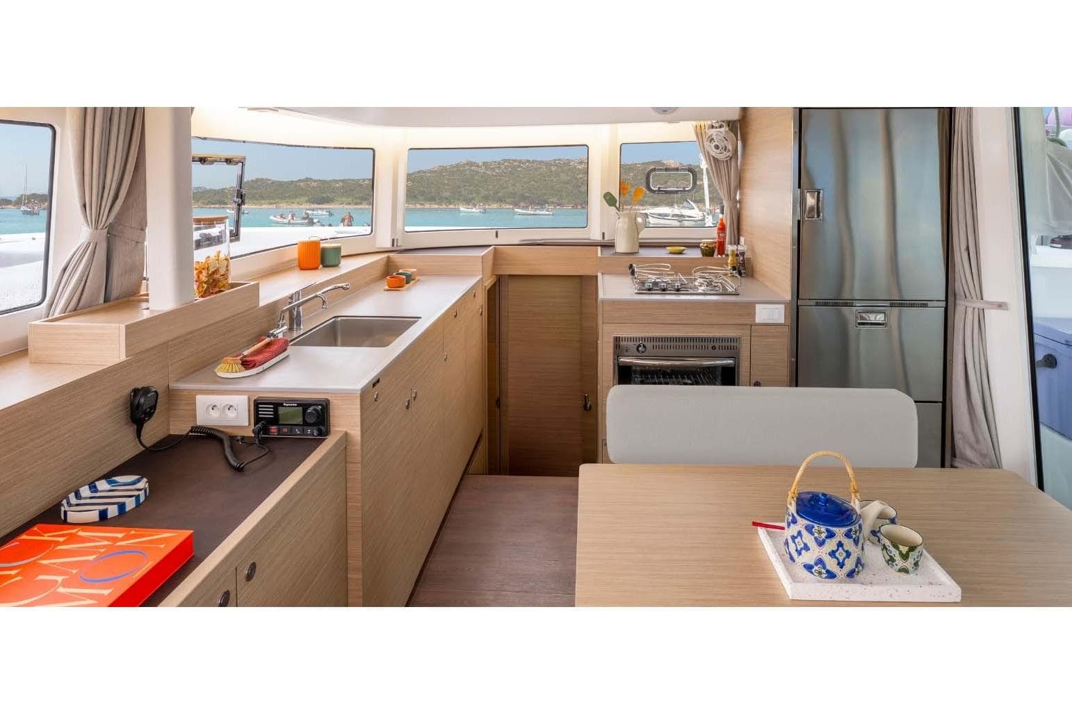 Manufacturer Provided Image: Modern kitchen interior of 2026 Lagoon 38 yacht with scenic ocean view.
