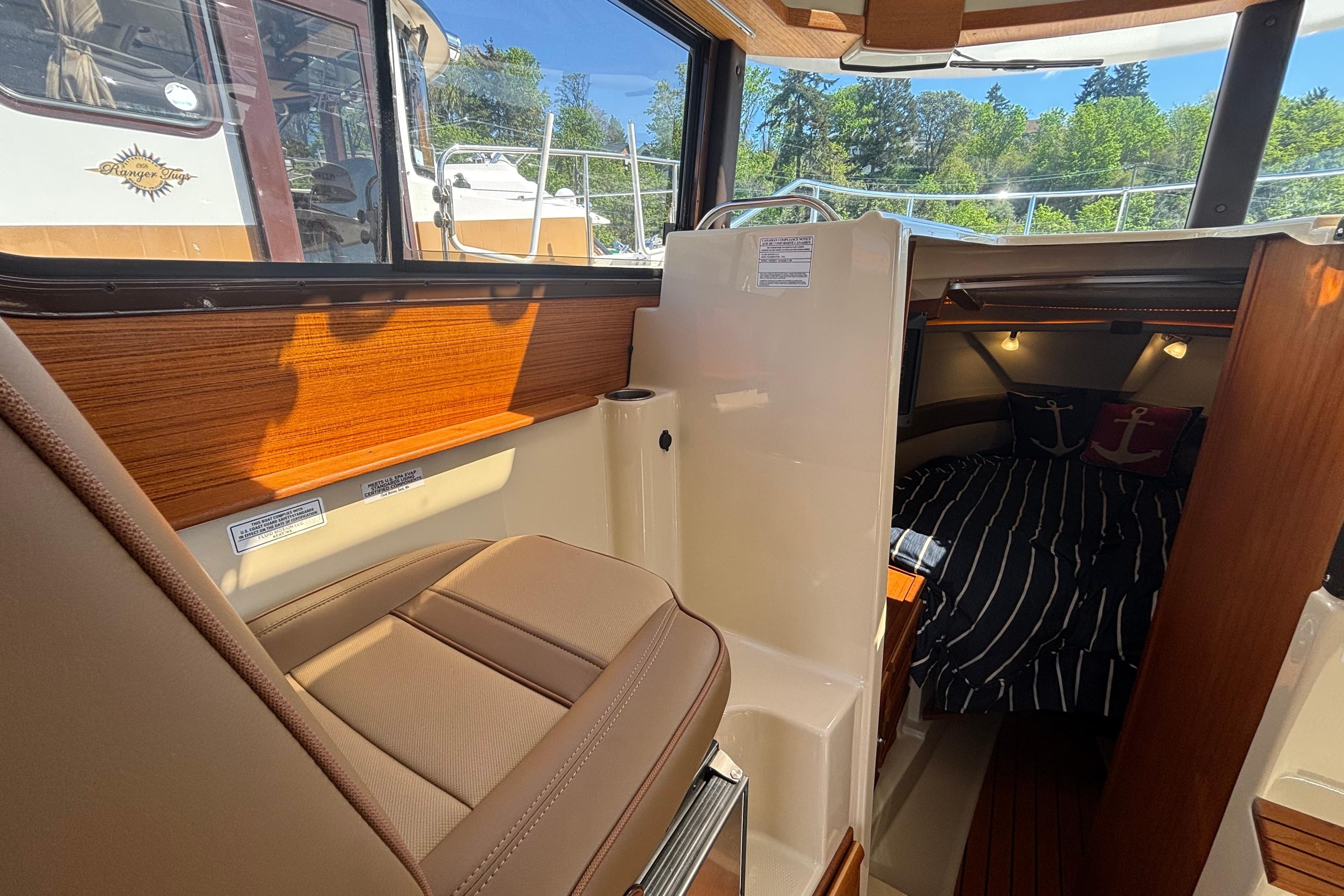 2022 Ranger Tugs R-27 interior with cozy cabin and nautical-themed bedding.
