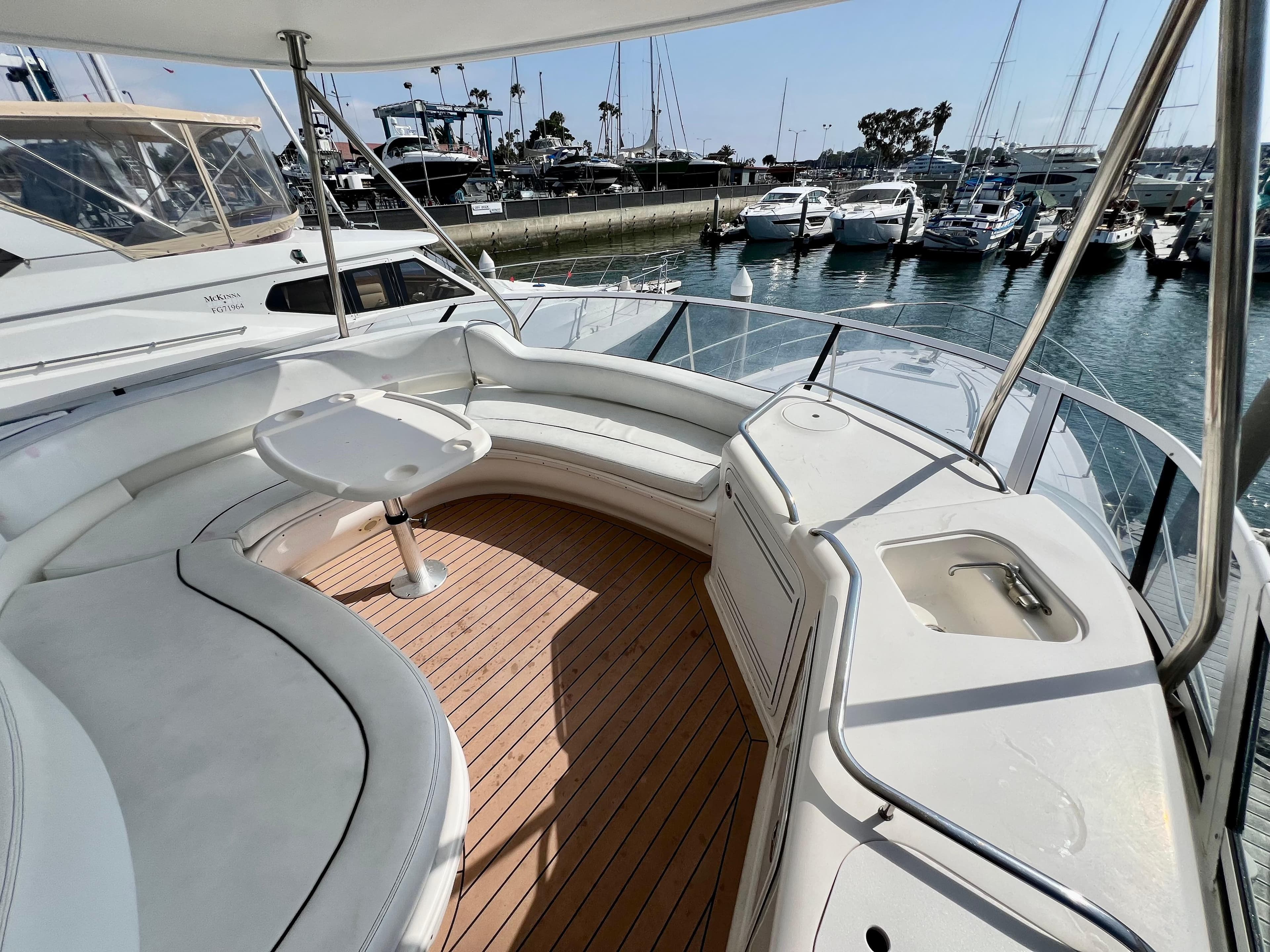 2002 Sea Ray 560 Sedan Bridge yacht with spacious deck and marina view.