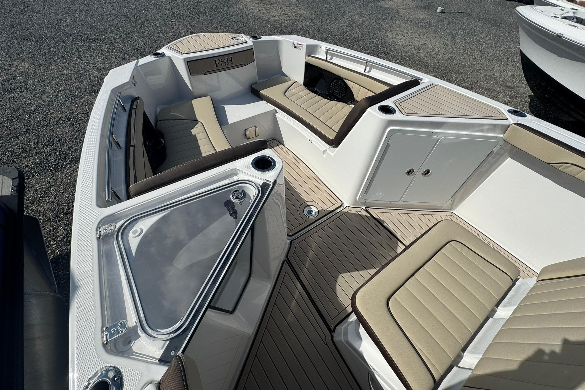 2026 Yamaha Boats 255 FSH Sport H interior with beige seating and storage compartments.