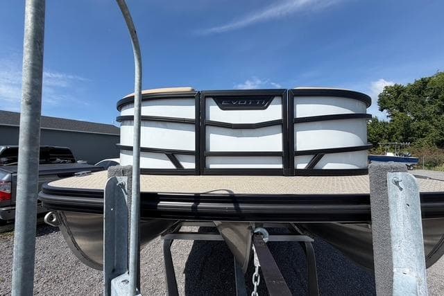 Evotti 523CS pontoon boat, 2026 model, parked on trailer under clear blue sky.