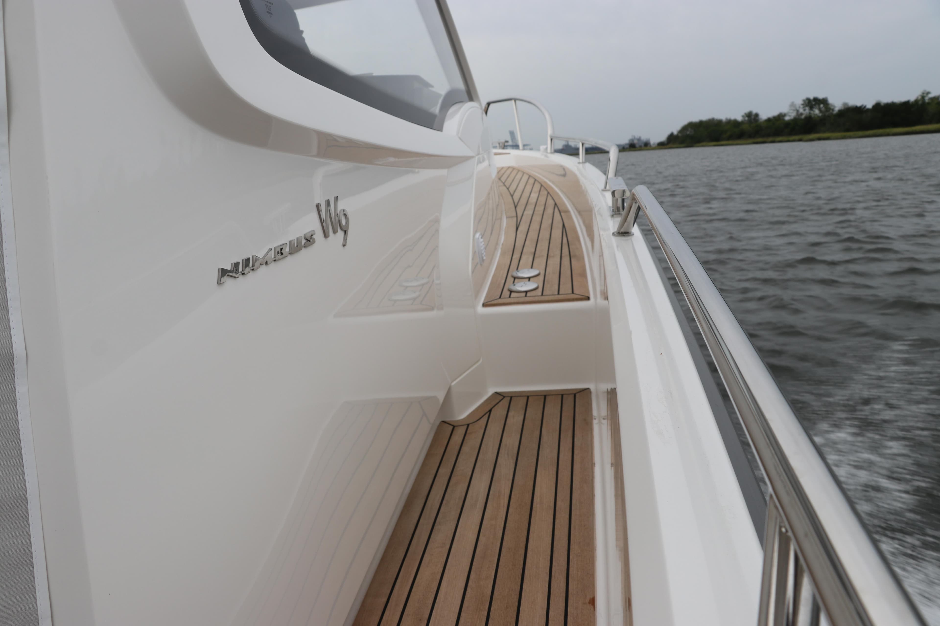 2024 Nimbus Weekender 9 boat with sleek design and wooden deck on water.