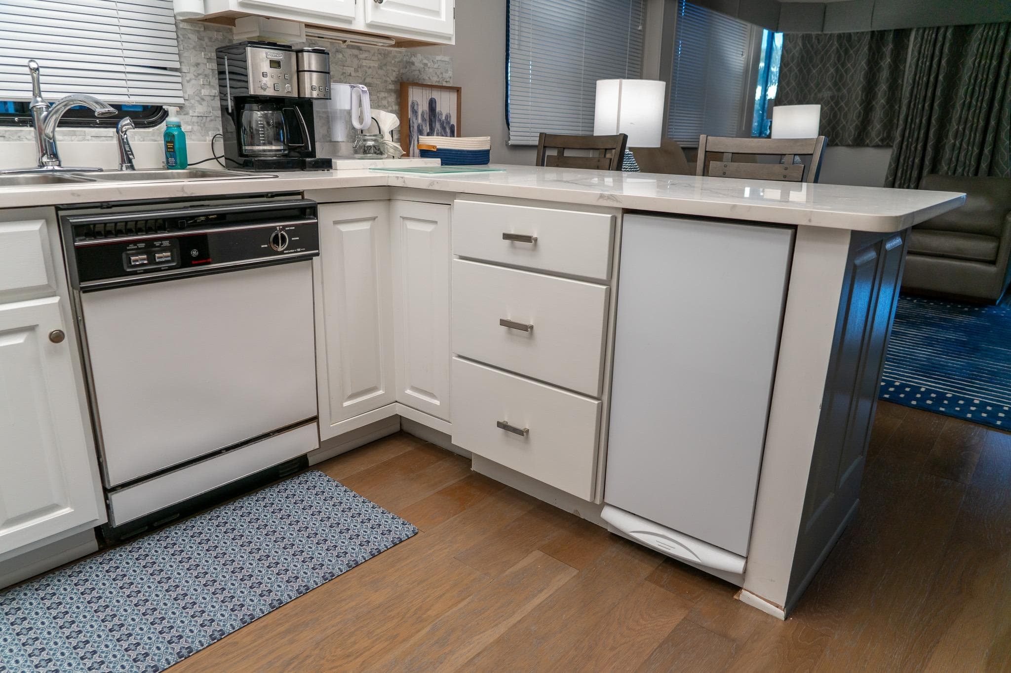 Modern kitchen interior on 1996 Lakeview 66 x 16 Widebody Houseboat, featuring white cabinetry.