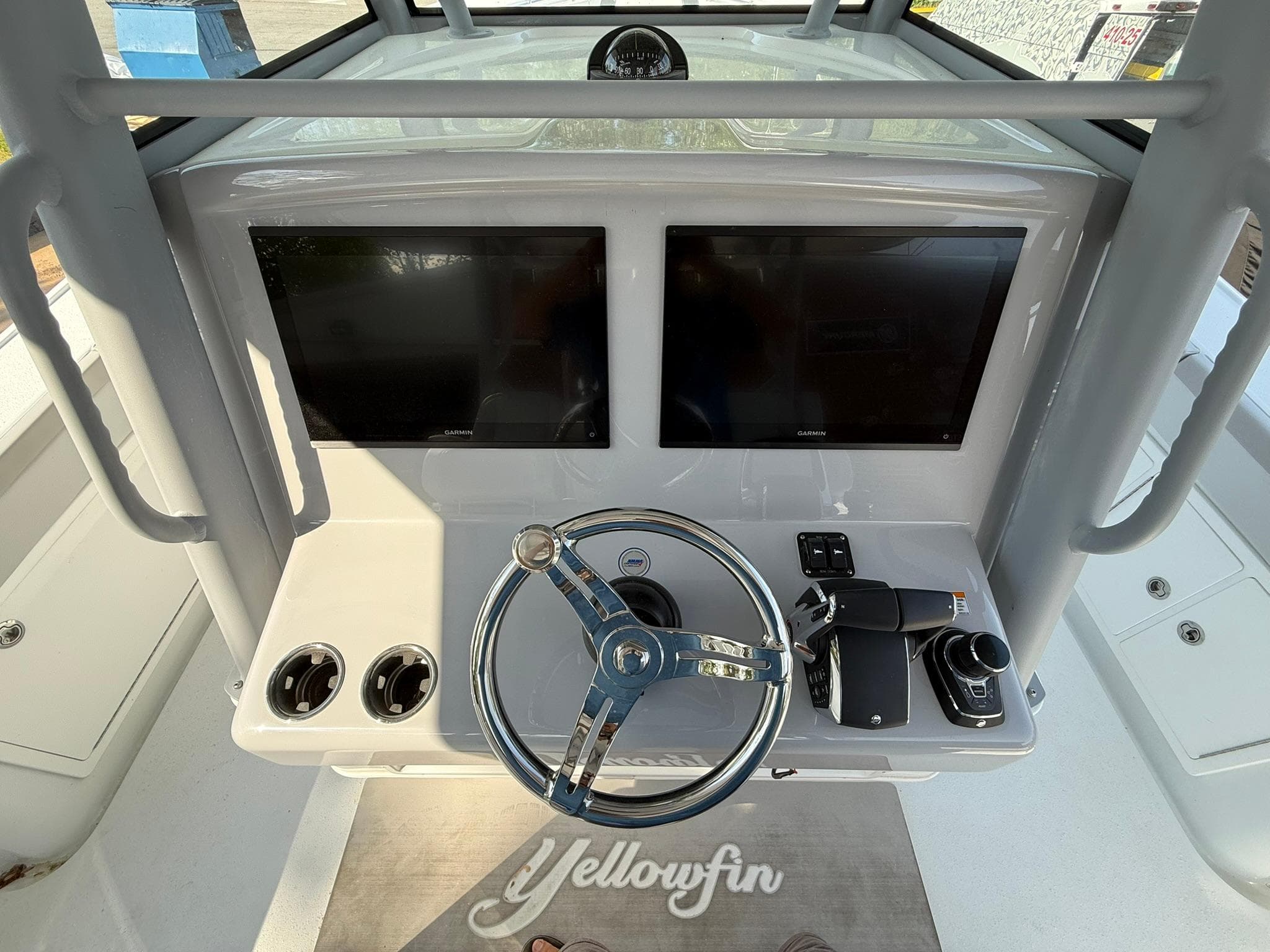 2025 Yellowfin 39 Offshore boat dashboard with dual screens and steering wheel.