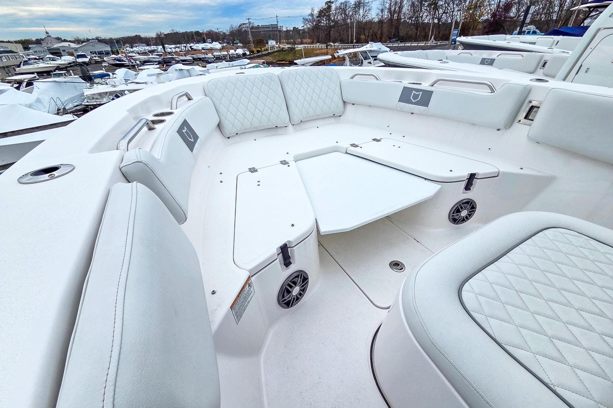 2026 Sea Fox 228 Commander boat interior with white cushioned seating and table.