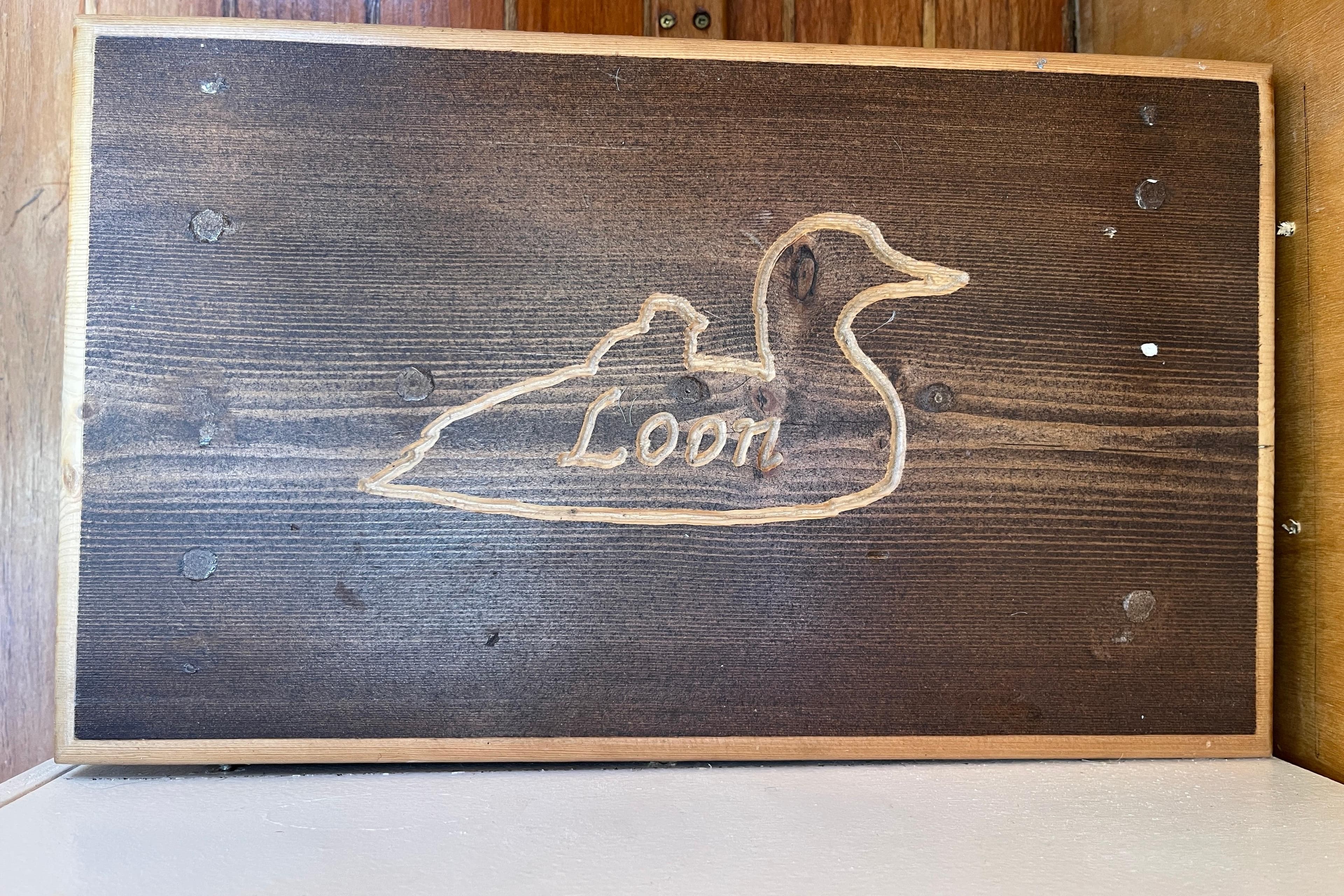 Wooden plaque with carved loon design on Nimble Kodiak Pilothouse Motor Sailor, 1994.