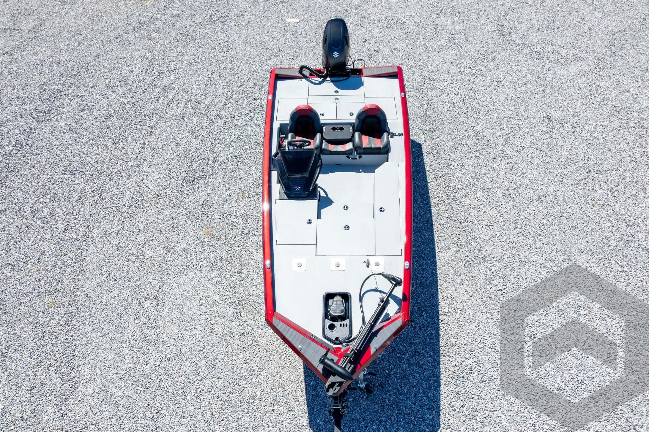 2026 Vexus Defender 189 boat, aerial view, red and gray design on gravel surface.