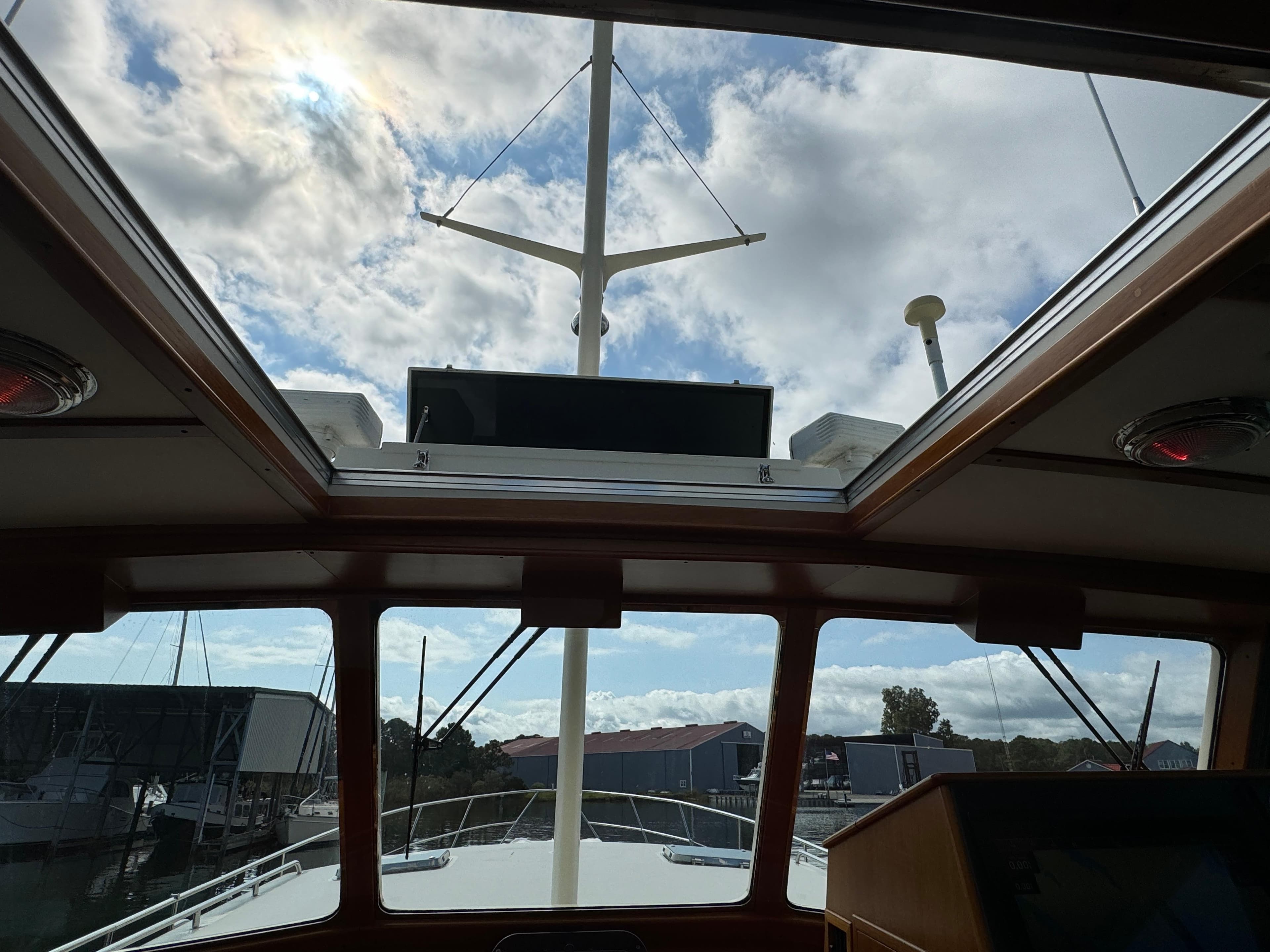 Interior view of 2003 Dettling 51 Express Cruiser with skylight and marina backdrop.