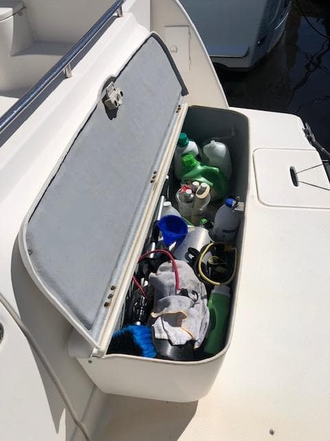 Open storage compartment on 2004 Meridian 459 Motoryacht with cleaning supplies.