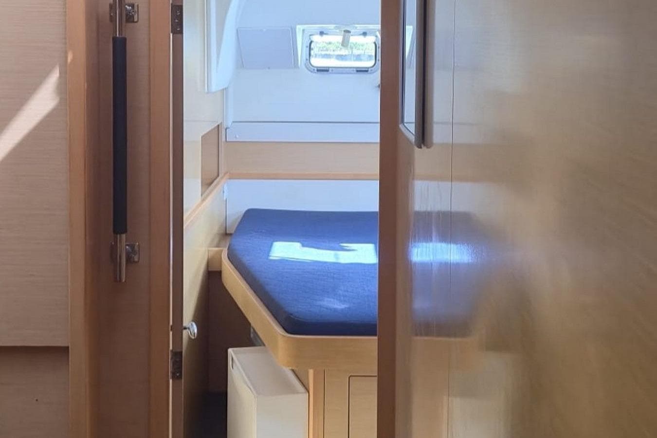 Interior cabin of 2017 Lagoon 400 S2 yacht with blue bedding and wooden finish.