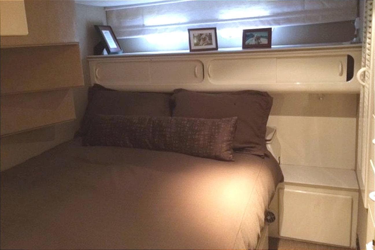 1977 Hatteras 58 Yacht Fisherman bedroom with cozy bed and soft lighting.