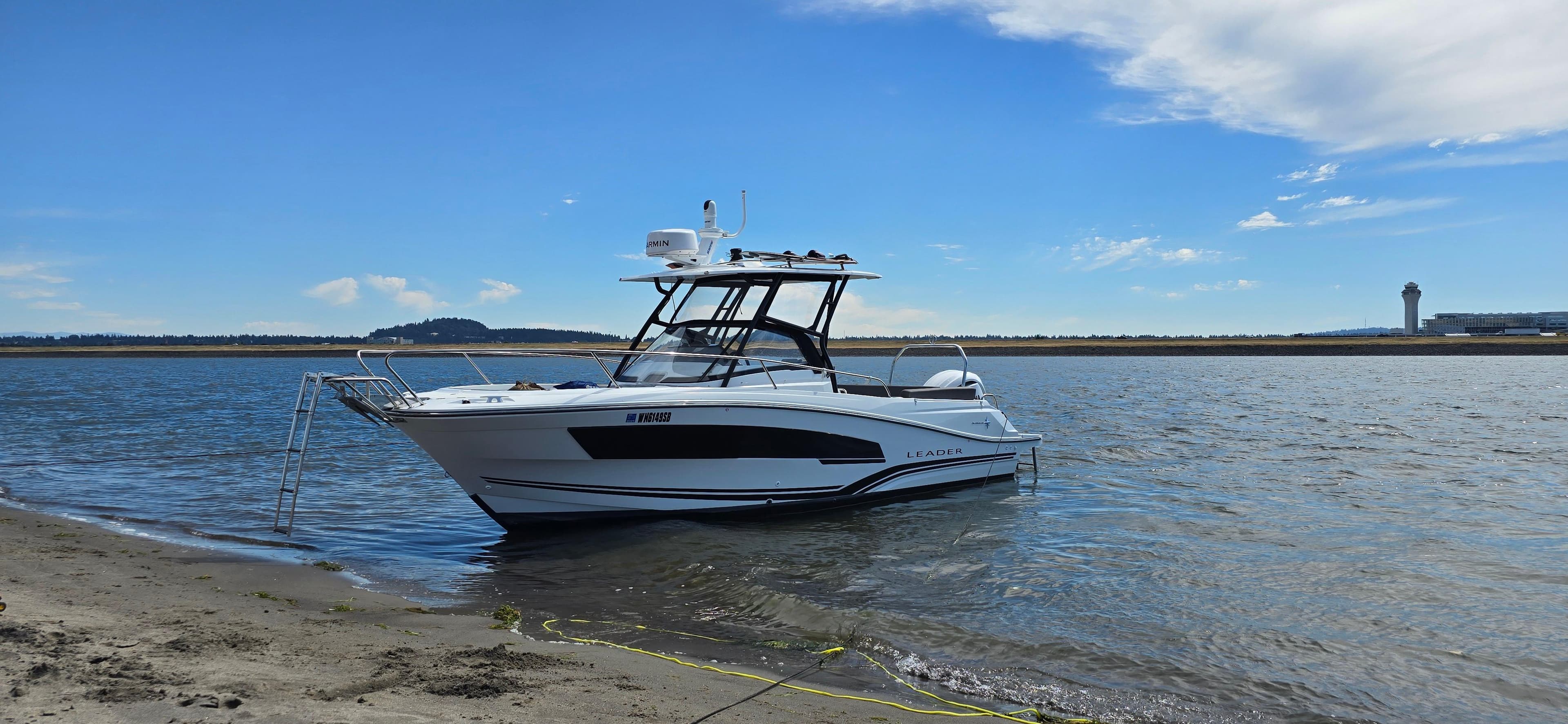 2022 Leader 7.5 WA boat anchored near sandy shore under blue sky.
