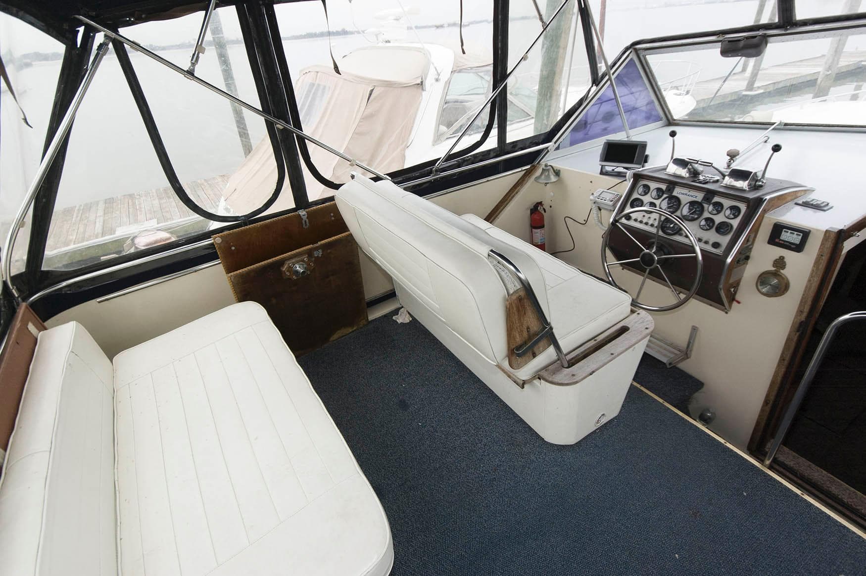 1984 Chris-Craft 350 Catalina boat interior with white seating and control panel.