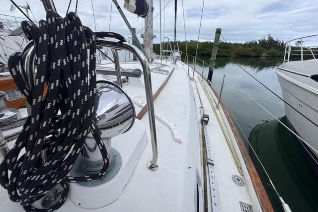 Deck view of a 1996 Beneteau 50 sailboat, featuring rigging and calm waters.