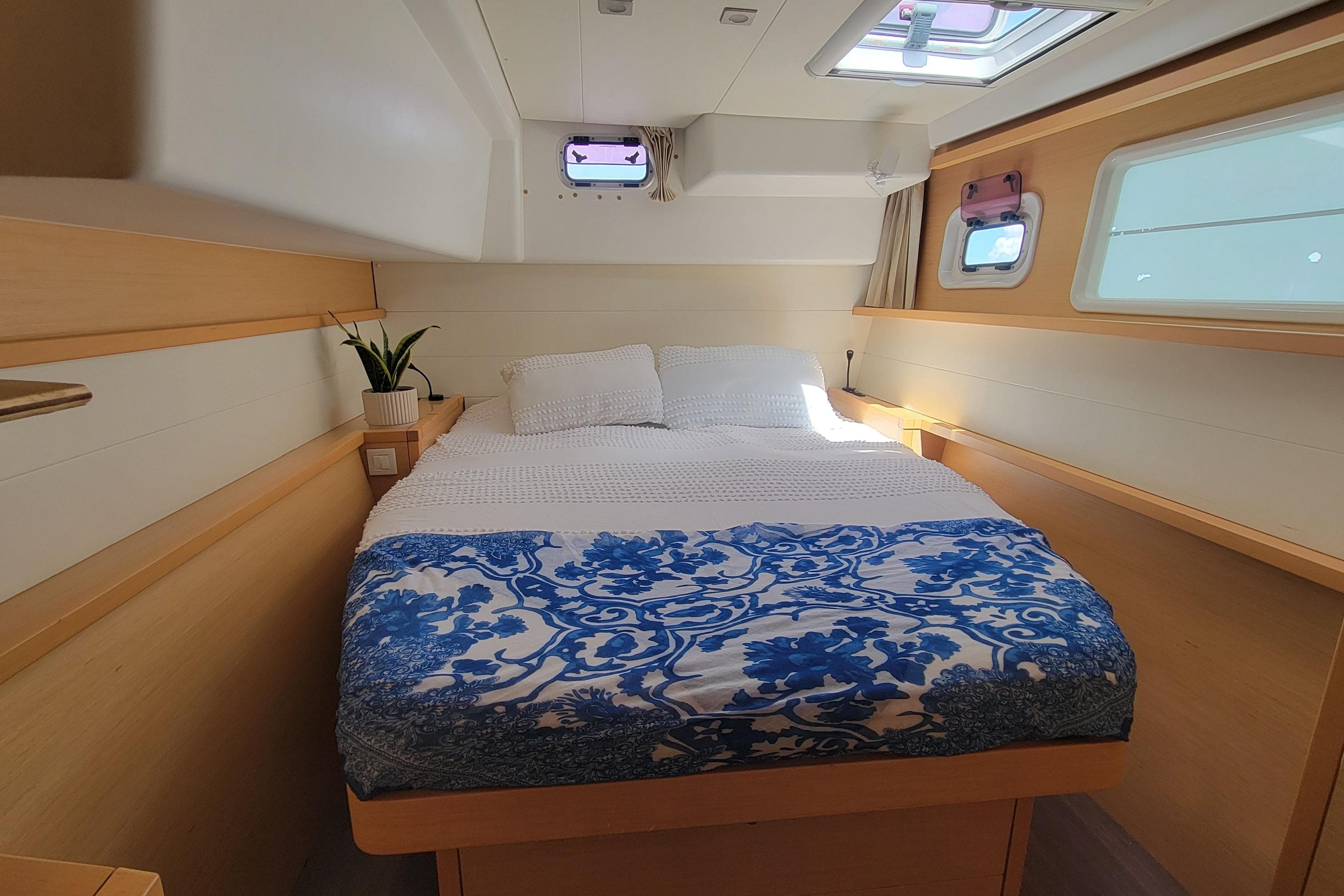 Interior cabin of 2012 Lagoon 450 catamaran with cozy bed and nautical decor.
