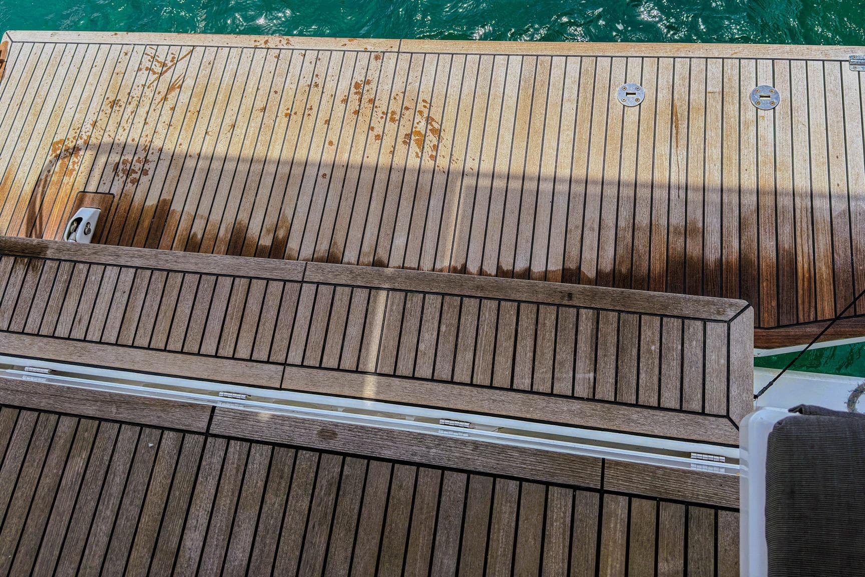 Teak deck of 2020 Beneteau Oceanis 46.1 yacht with water stains.