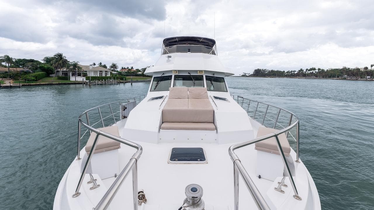 1998 Hatteras 74 Sport Deck Motor Yacht on calm water, featuring spacious deck and seating.