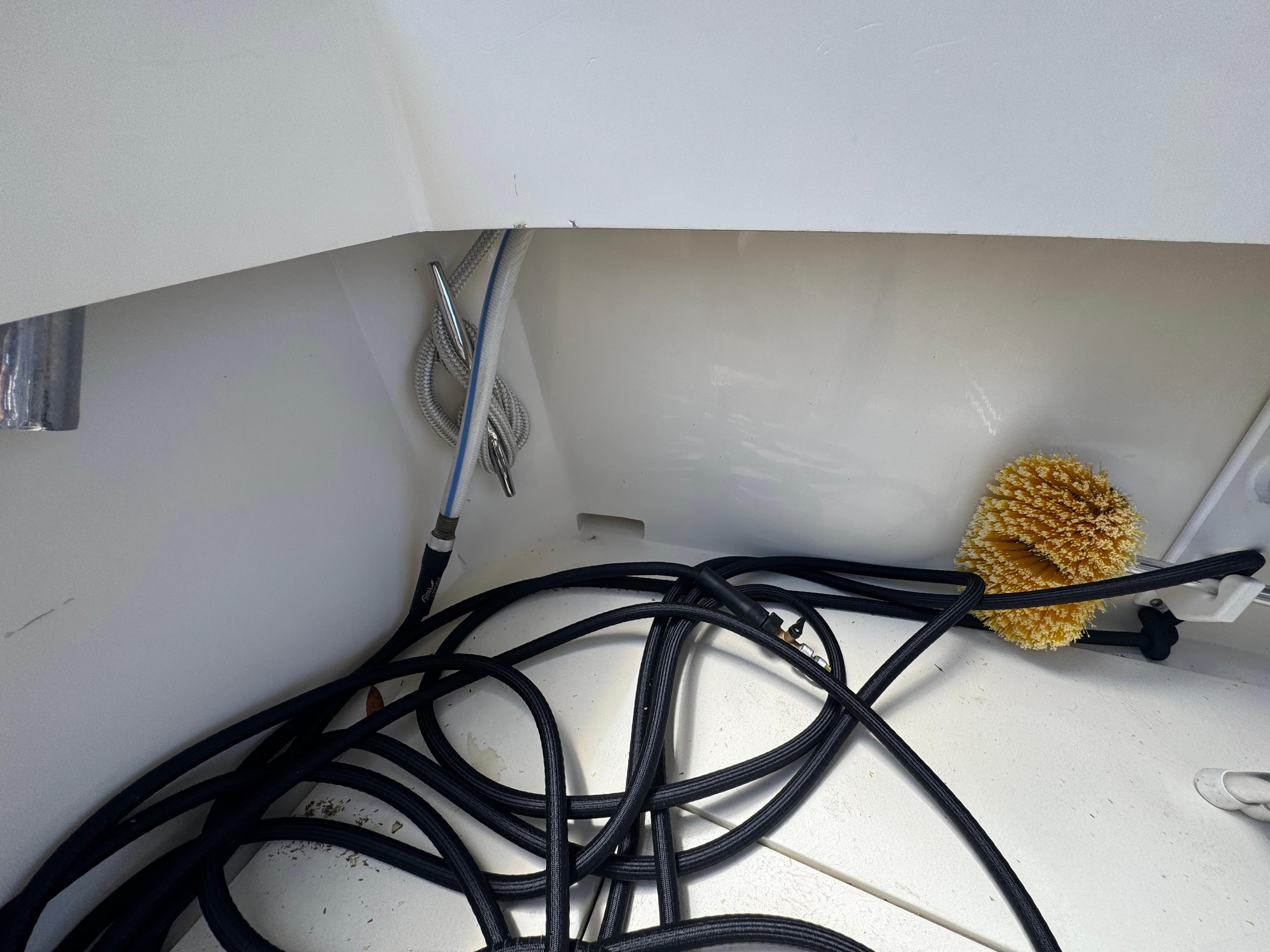 Tangled hoses and cleaning brush in a 1990 Viking 35 boat compartment.