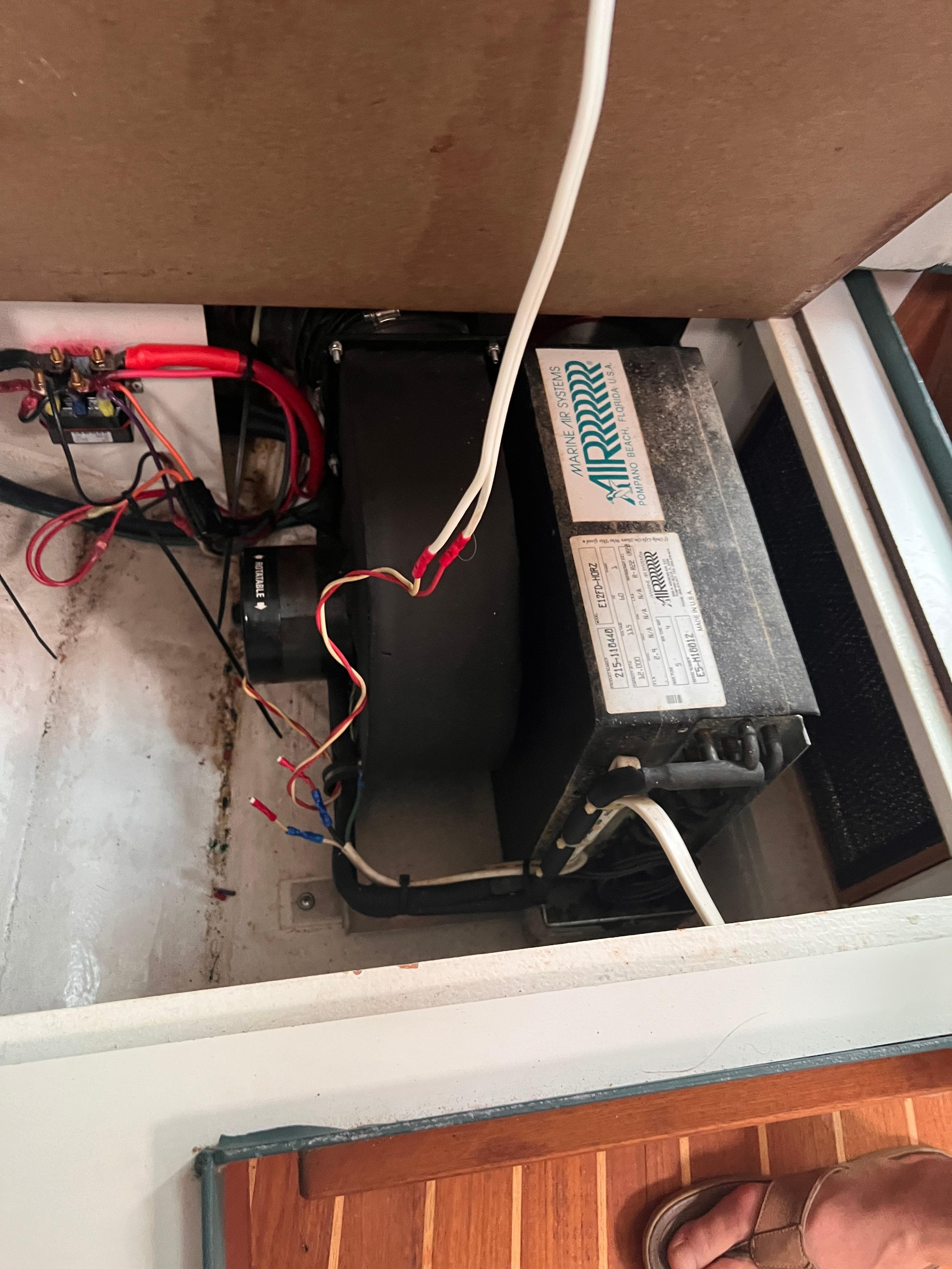 Electrical components inside a 1996 Pursuit 3100 Open boat, featuring wiring and an air conditioning unit.
