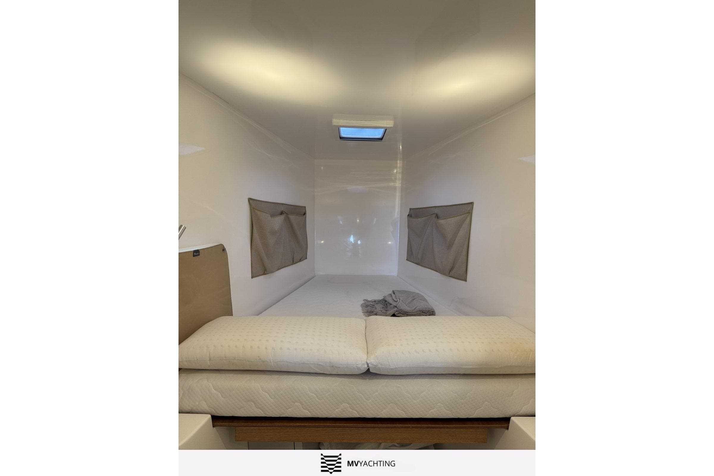 Interior cabin of 2022 NEEL 43 yacht with bed and skylight.
